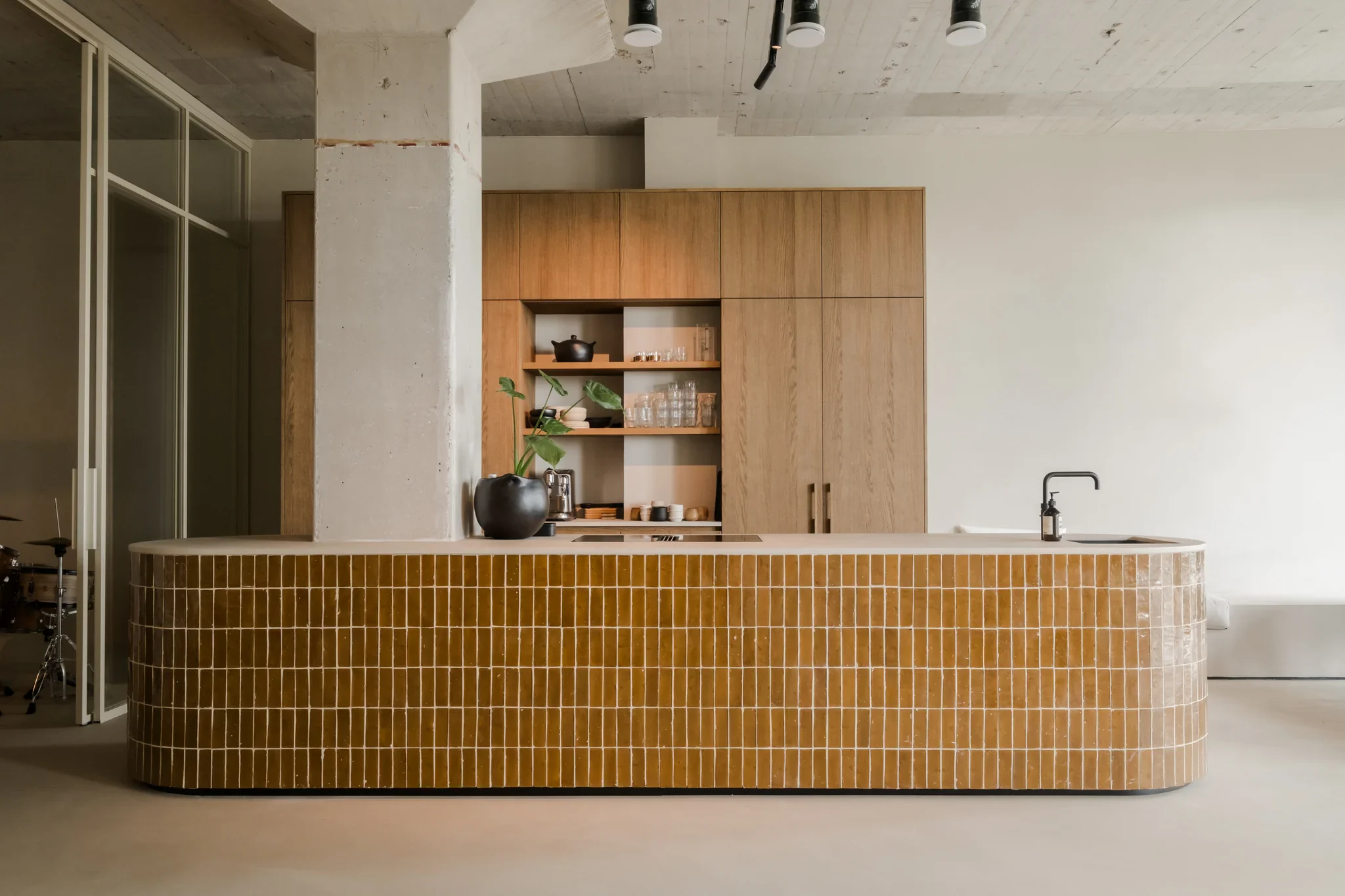Woningfotografie Haarlem van open keuken met okergeel tegelwerk en houten kastenwand