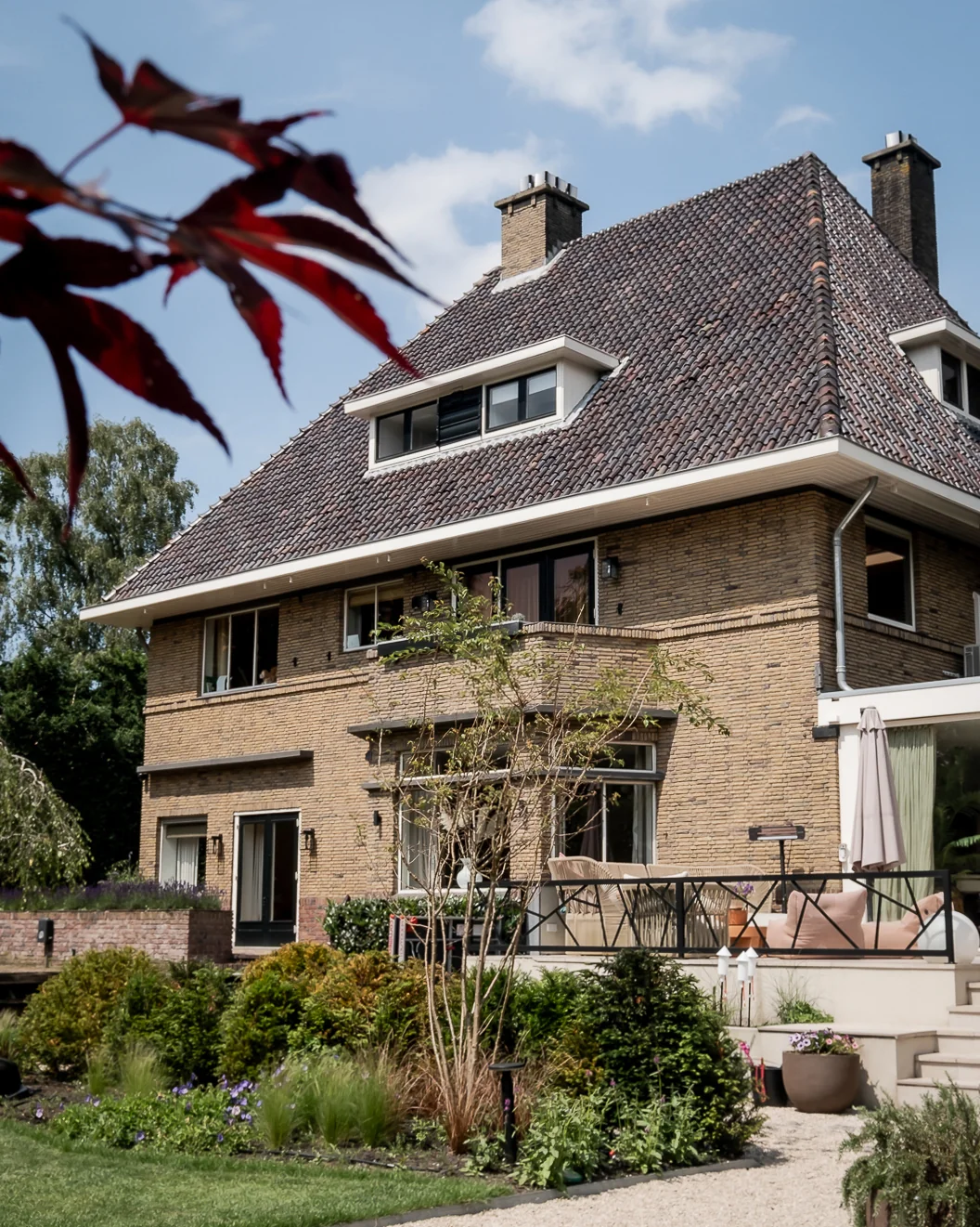 Woningfotografie in Kralingen van een bakstenen villa met dakkapel en besloten terras in de tuin