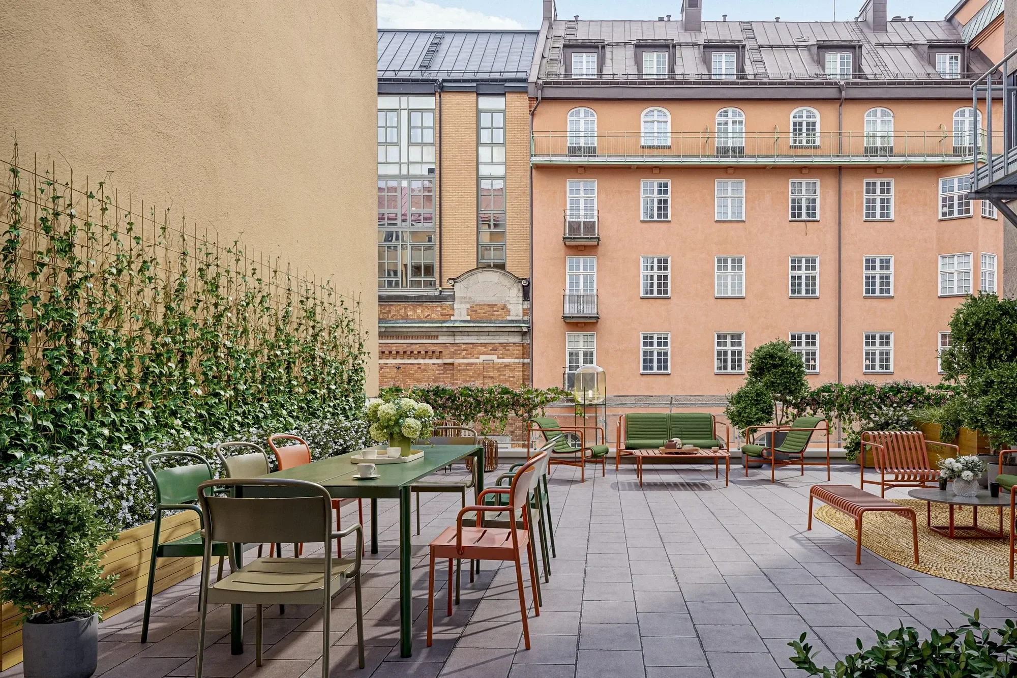 Virtual staging dakterras Antwerpen met groene en terracotta tuinmeubelen tussen stadsgevels