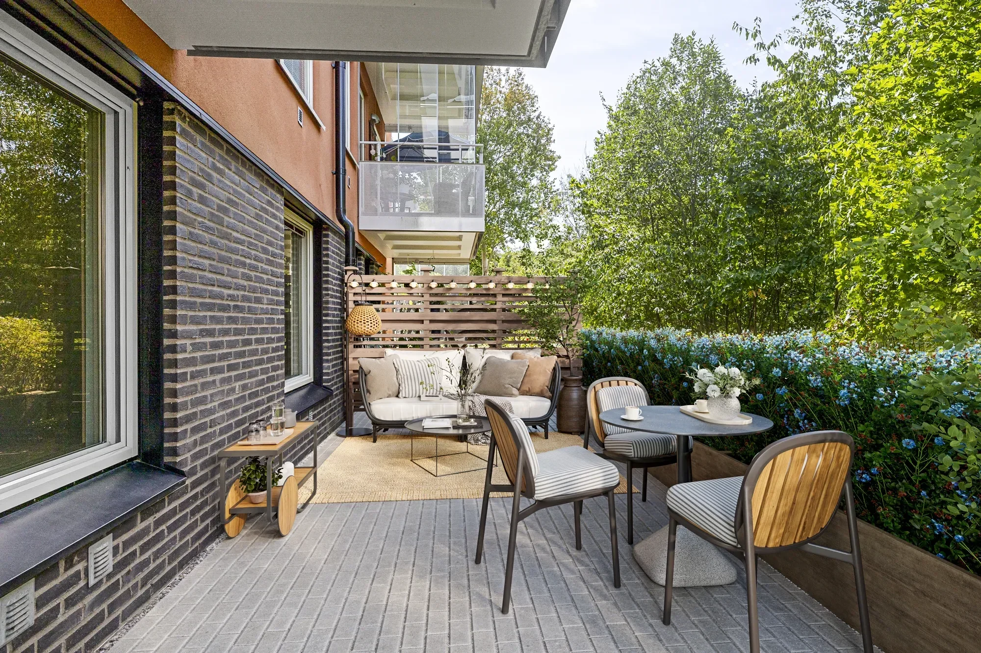 Virtual staging terras Den Haag met loungebank, eettafel en stoelen tussen groene beplanting